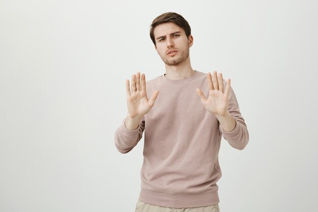 Widerstrebender unzufriedener Mann, der ohne Ablehnung die Hand schüttelt