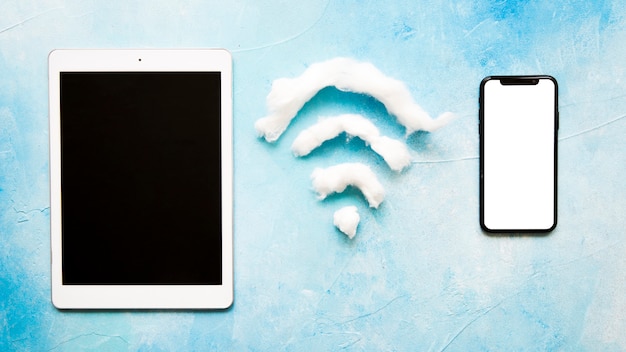Wifi-Symbol zwischen Handy und Tablette auf blauem Hintergrund