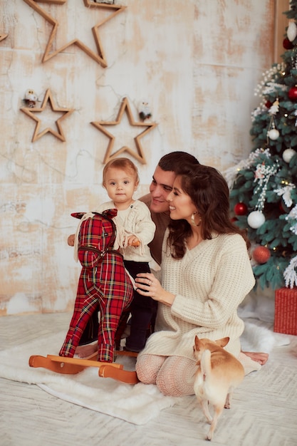 Winterferien Dekorationen. Warme Farben. Familienporträt. Mama, Papa und ihre kleine Tochter