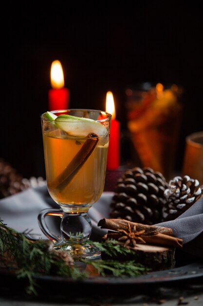 Wintergetränk mit Zimtstange und Apfelscheibe im Weihnachtstisch