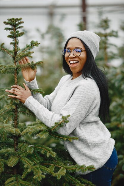 Winterkonzept. Frau in einem grauen Pullover. Verkäuferin von Weihnachtsbaum.