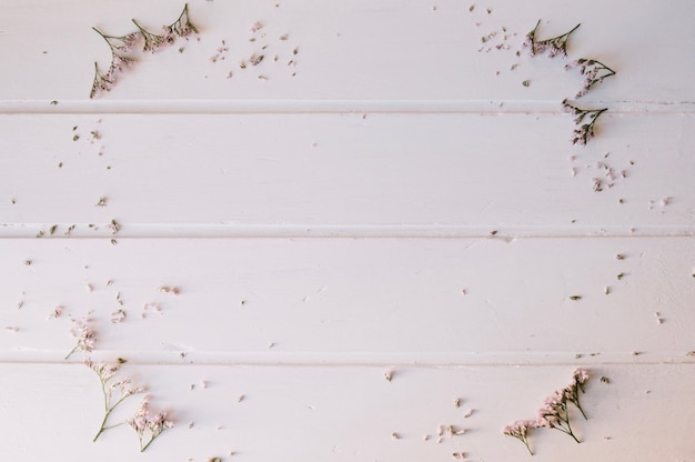 Kostenloses Foto winzige blumen bilden einen kreis über einem holztisch