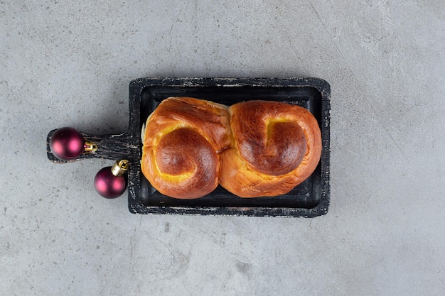 Kostenloses Foto wirbelndes süßes brötchen auf einem kleinen tablett auf marmortisch.