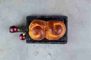 Kostenloses Foto wirbelndes süßes brötchen auf einem kleinen tablett auf marmortisch.