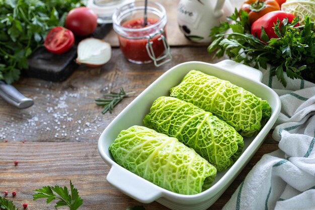 Kostenloses Foto wirsingrollen gefüllt mit fleischreis und gemüse auf einem rustikalen tisch