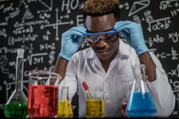 Wissenschaftler betrachten die gelbe Chemikalie im Glas im Labor