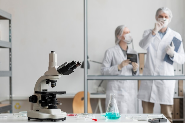 Kostenloses Foto wissenschaftler mit mittlerem schuss diskutieren im labor