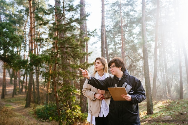 Wissenschaftler untersuchen Pflanzenarten und inspizieren Bäume im Wald.