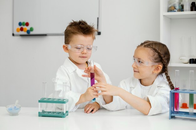 Wissenschaftler von Jungen und Mädchen machen Experimente im Labor mit Reagenzgläsern