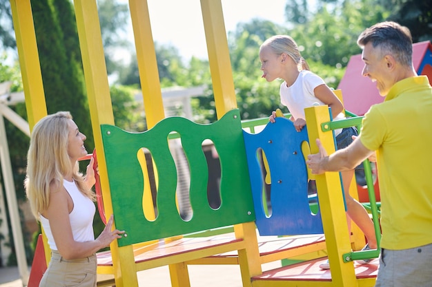 Wochenende. Familie verbringt Zeit auf dem Spielplatz und schaut genossen