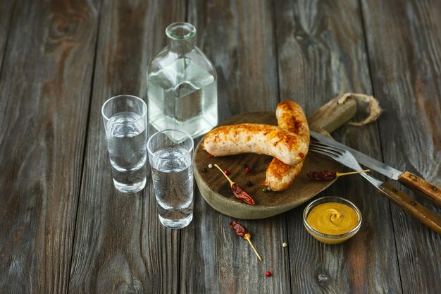 Wodka und traditioneller Snack auf Holzwand