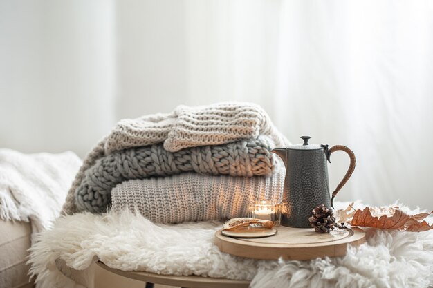 Wohnstillleben mit gestrickten Pullovern und Teekanne Tee auf unscharfem Hintergrundkopierraum.
