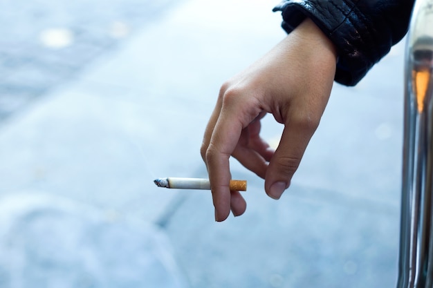 Kostenloses Foto womans hand mit zigarette auf der straße.