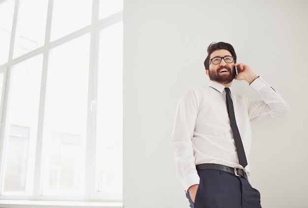 Worker Gespräch am Telefon nahe dem Fenster