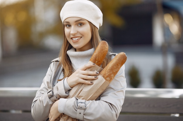 Wowan in einer weißen Baskenmütze in einer Stadt mit einem Baguette