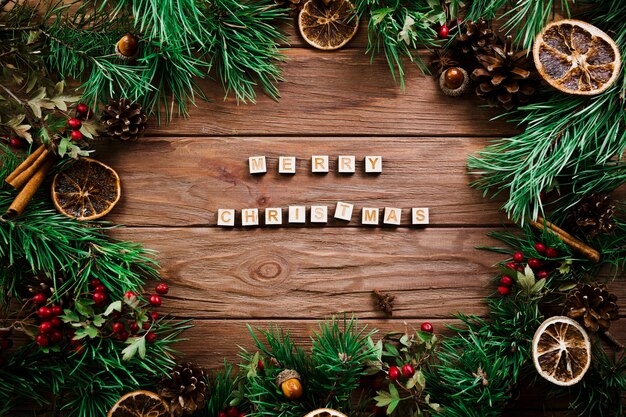 Würfel mit Buchstaben in der Nähe von Weihnachtszweigen