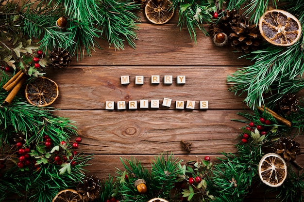 Würfel mit Buchstaben in der Nähe von Weihnachtszweigen