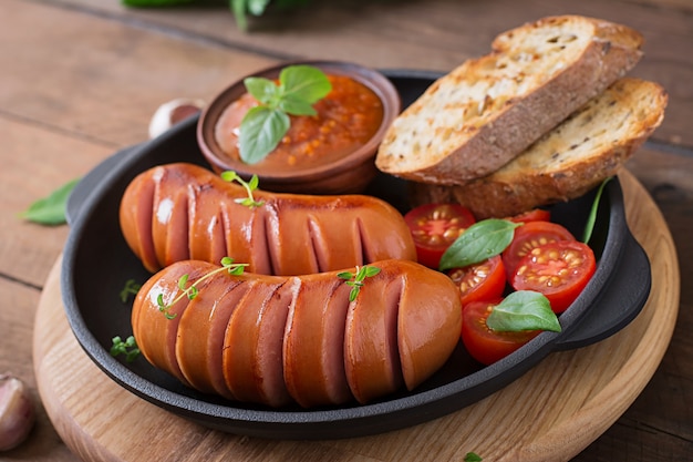 Würstchen auf der Grillpfanne auf dem Holztisch