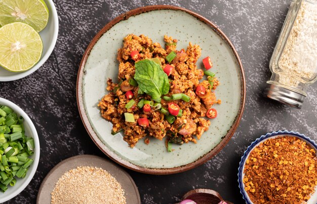 Würziger gehackter Schweinefleischsalat mit Chiliflocken, Limette, gehackten Frühlingszwiebeln, Chili und geröstetem Reis