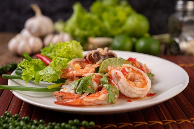 Würziger Tintenfisch-Garnelen-Salat in weißer Schüssel mit Zitronen-Koriander und Salat