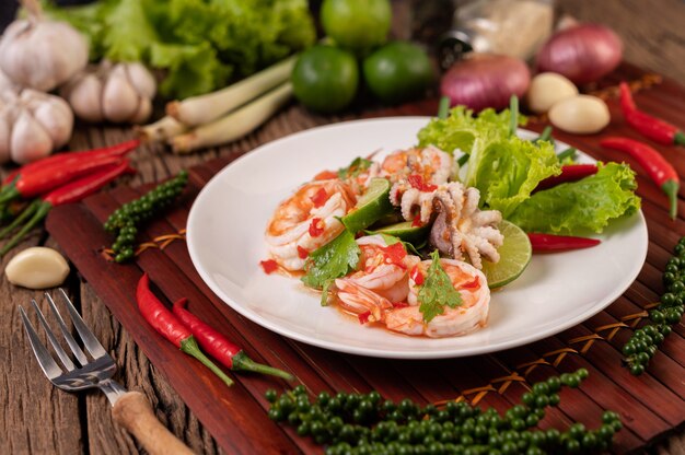 Würziger Tintenfisch-Garnelen-Salat in weißer Schüssel mit Zitronen-Koriander und Salat