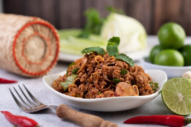 Würziges gehacktes Schweinefleisch in einem weißen Teller.