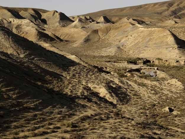 Wüstenstandort einsam und ruhig mit braunem Sand gegen blauen Himmel