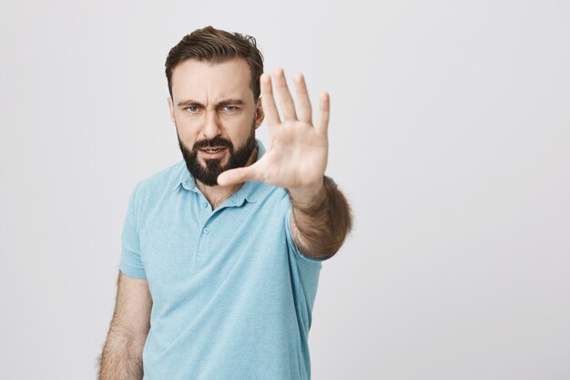 Wütender ernsthafter Mann streckt die Hand aus, zeigt Stoppgeste, Einschränkung