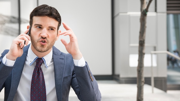 Kostenloses Foto wütender geschäftsmann, der telefongespräch hat