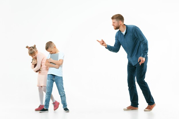 Wütender Vater schimpft zu Hause mit seinem Sohn und seiner Tochter.