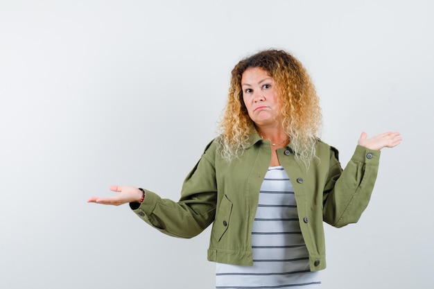 Kostenloses Foto wunderbare frau, die hilflose geste in der grünen jacke, im hemd zeigt und unentschlossen schaut, vorderansicht.