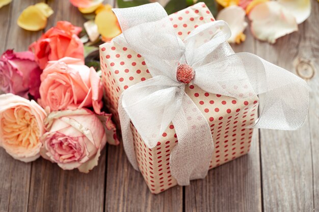 Wunderschön verpackte Geschenkbox und frische Rosen zum Valentinstag oder Frauentag. Urlaubskonzept.