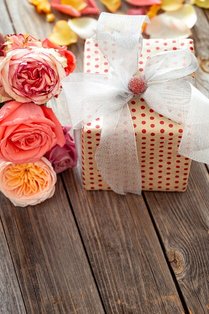 Wunderschön verpackte Geschenkbox und frische Rosen zum Valentinstag oder Frauentag. Urlaubskonzept.