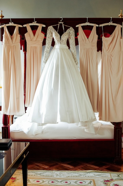 Wunderschöne Brautkleid und beige Kleider für Brautjungfern hängen über die schlechte