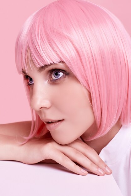 Wunderschöne Frau mit rosa Haaren posiert