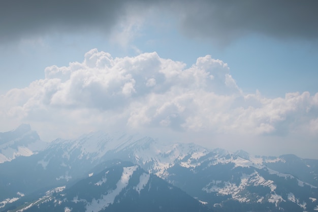 Wunderschöne Landschaft aus weißen Wolken, die die hohen felsigen Berge bedecken