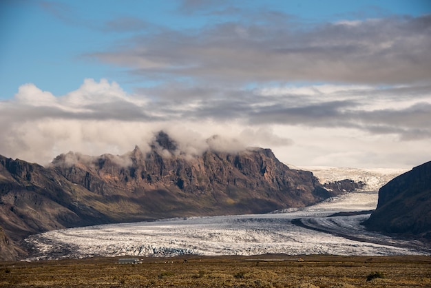 Wunderschöne Landschaft der Gletscher Islands unter wunderschönen weißen flauschigen Wolken