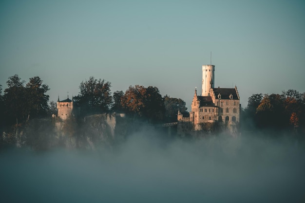 Wunderschöne Landschaft des Schlosses Lichtenstein Deutschland neben grünen Bäumen unter blauem Himmel