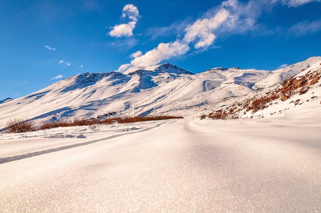 Wunderschöner Flachwinkelschuss einer atemberaubenden Gebirgslandschaft, die mit Schnee in den Andenkordilleren bedeckt ist