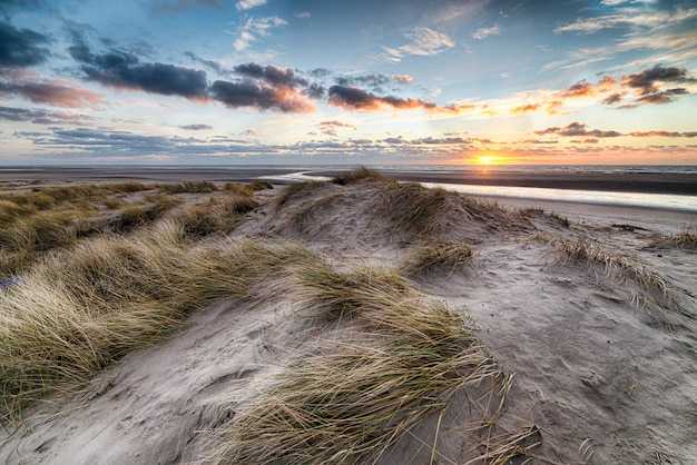 Kostenloses Foto wunderschöner sonnenaufgang am strand, der die perfekte kulisse für morgendliche spaziergänge am ufer schafft