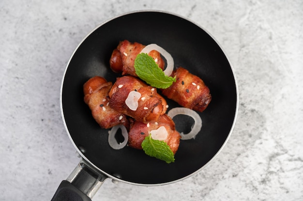 Wurst eingewickelt in Schweinebauch in einer Pfanne.