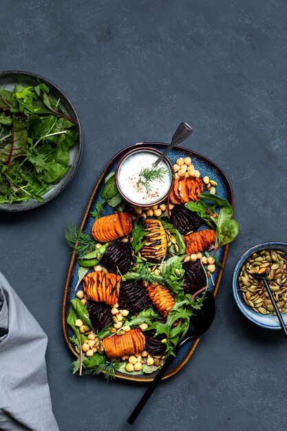 Wurzelgemüse in der Mitte weich und knusprig braten mit Kichererbsen Kürbiskernen und frischen Salatblättern Gesunder frischer Salat