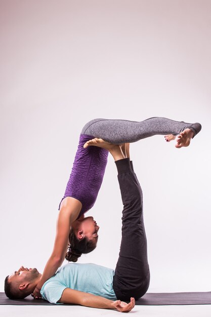 Yoga-Konzept. Junges gesundes Paar in der Yoga-Position auf weißem Hintergrund