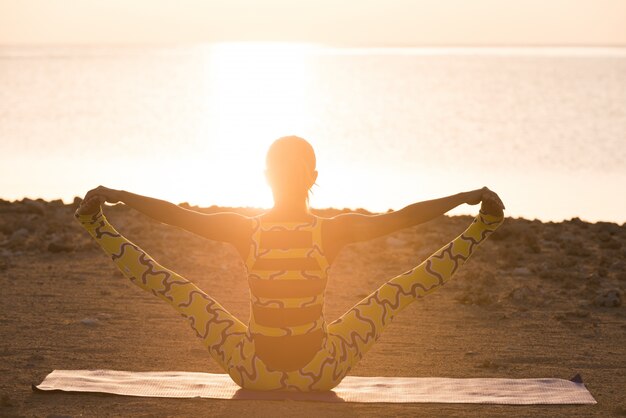 Yoga-Praxis Frau macht Asana bei Sonnenaufgang