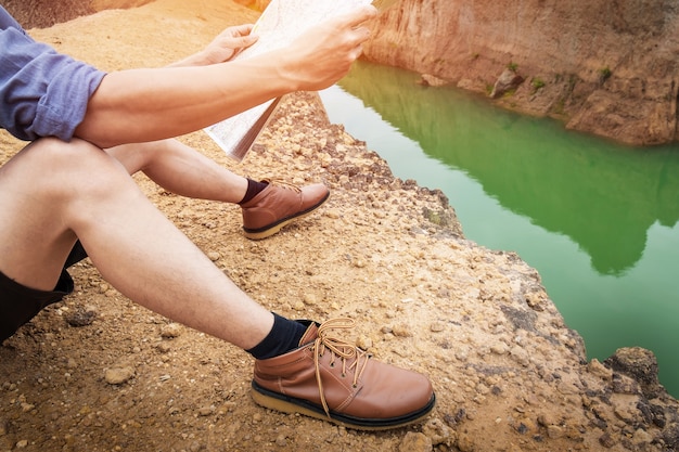 Kostenloses Foto young man traveller mit rucksack entspannenden outdoor mit felsigen berge auf hintergrund sommer urlaub und lifestyle wandern konzept.