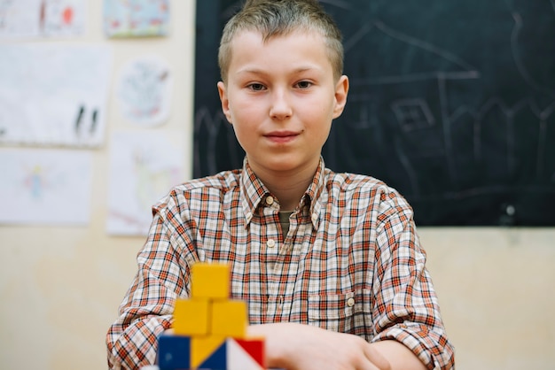 Kostenloses Foto youngster sitzt mit puzzle