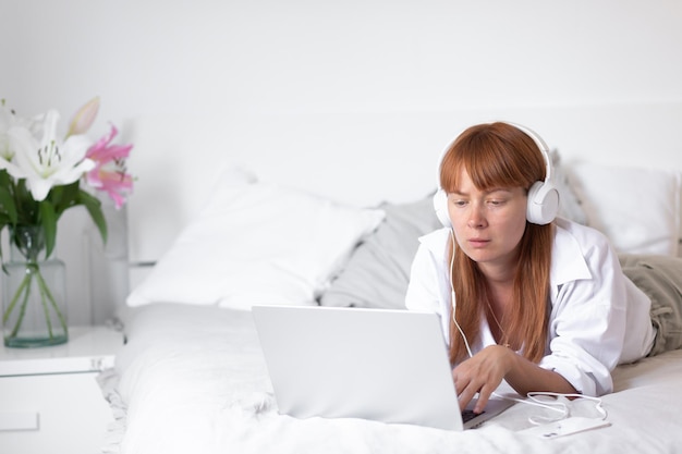 Yyoung Mädchen hört Musik und arbeitet am Computer Blumenlilie drinnen