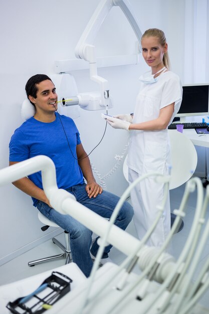 Zahnärztin, die Röntgenaufnahmen der Zähne des Patienten macht