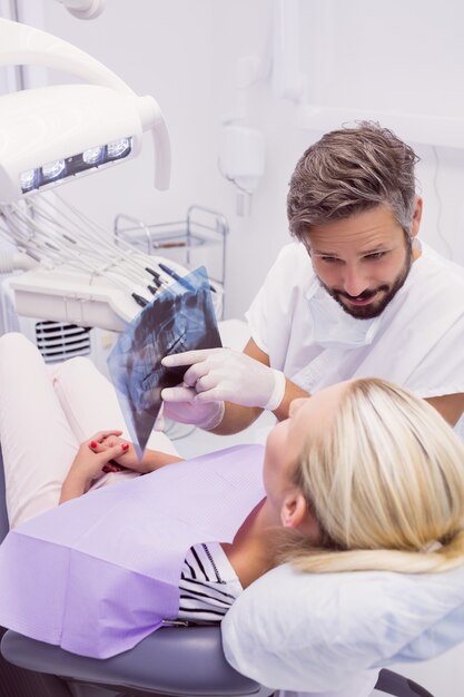 Zahnarzt, der dem Patienten Röntgen zeigt
