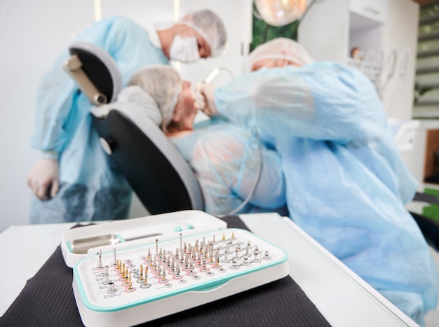 Zahnarzt und sein Assistent arbeiten mit einem Patienten in einem Zahnarztstuhl in der Zahnarztpraxis